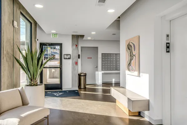 a living room with furniture a large window and a chandelier