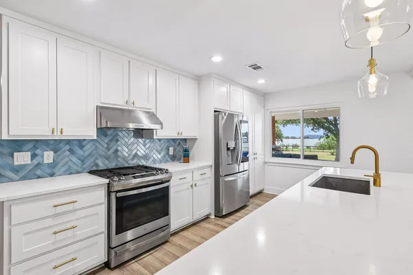 a kitchen with refrigerator a stove a sink dishwasher a refrigerator and cabinets with wooden floor