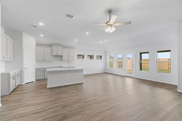 a kitchen with a sink cabinets and wooden floor