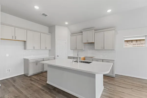 a view of kitchen with granite countertop cabinets and wooden floor