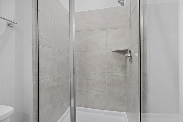 a large white kitchen with kitchen island a sink wooden floor and a refrigerator