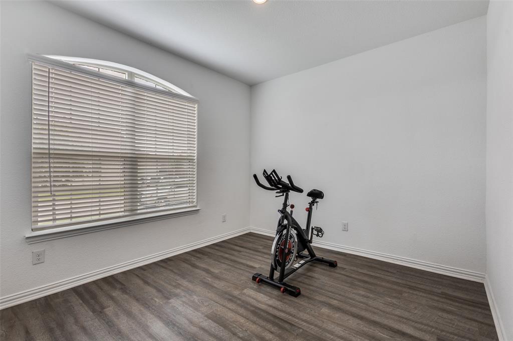 307 Red Cedar Drive Princeton, TX 75407 - Photo 19 of 26 Exercise room featuring dark wood-style floors and baseboards
