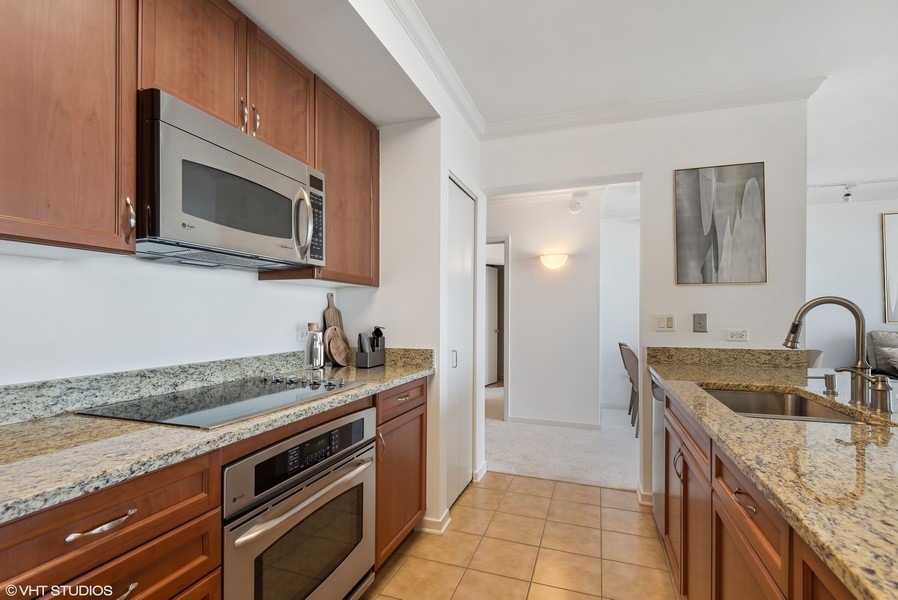 807 Davis Street, Unit 1307 Evanston, IL 60201 - Photo 2 of 22 a kitchen with granite countertop a stove top oven microwave and sink