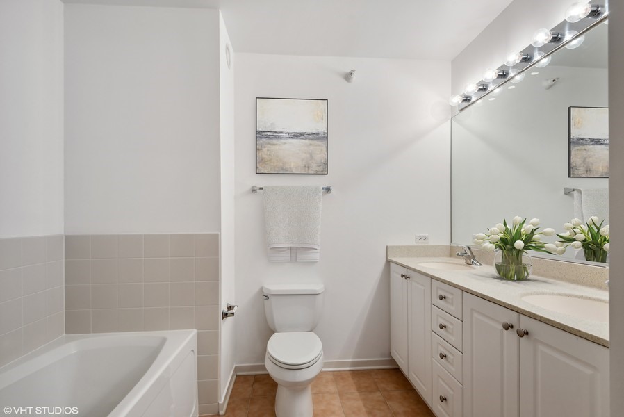 807 Davis Street, Unit 1307 Evanston, IL 60201 - Photo 6 of 22 a bathroom with a granite countertop sink a toilet a mirror and bathtub