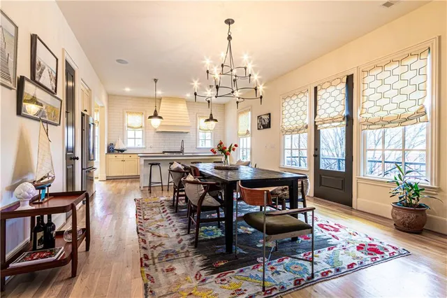 a kitchen with stainless steel appliances granite countertop a sink a stove a refrigerator and island with wooden floor