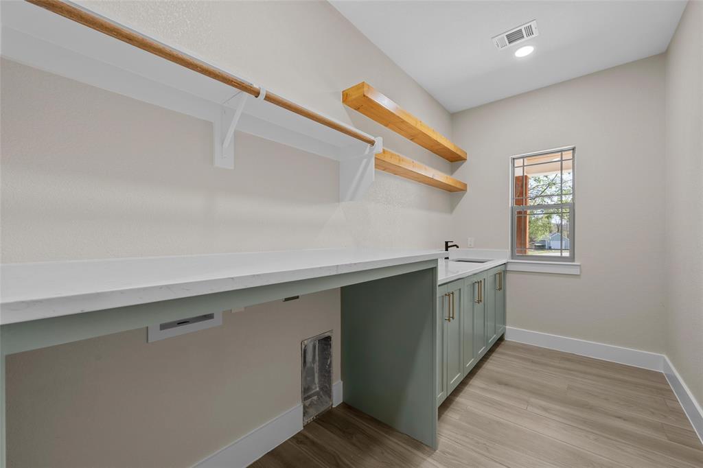 317 North Big Red Way China Spring, TX 76633 - Photo 16 of 40 a kitchen with a sink cabinets and wooden floor