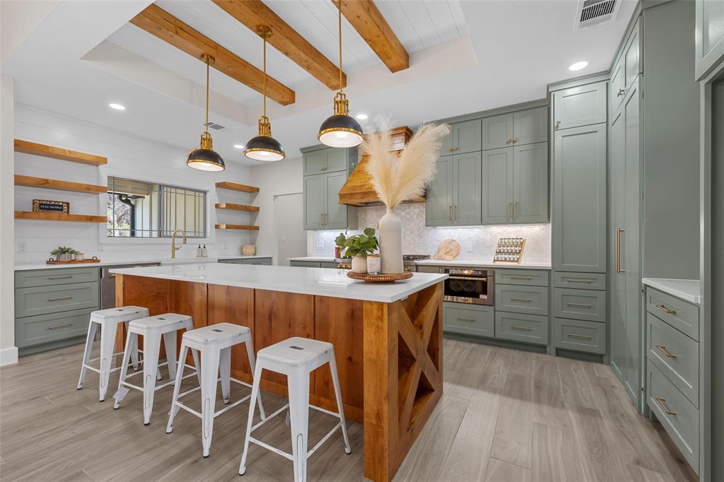 317 North Big Red Way China Spring, TX 76633 - Photo 8 of 40 a dining hall with stainless steel appliances kitchen island granite countertop a table chairs and a wooden floor