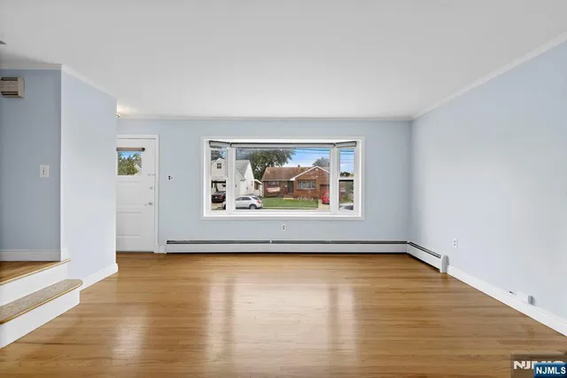a view of a room with wooden floor and window