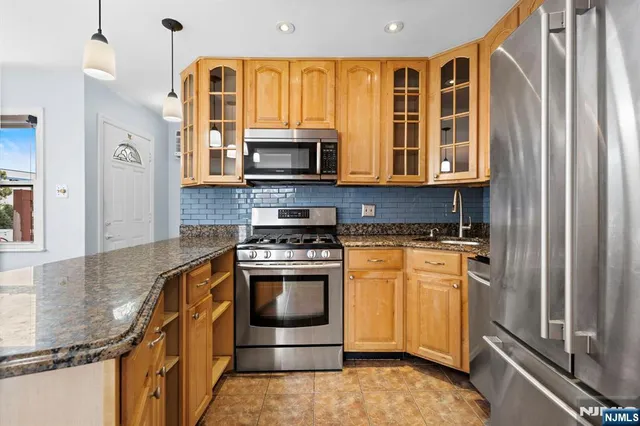 a kitchen with stainless steel appliances granite countertop a stove a microwave and a refrigerator