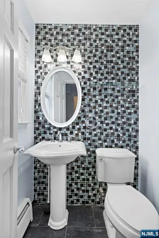 a bathroom with a sink toilet and a mirror