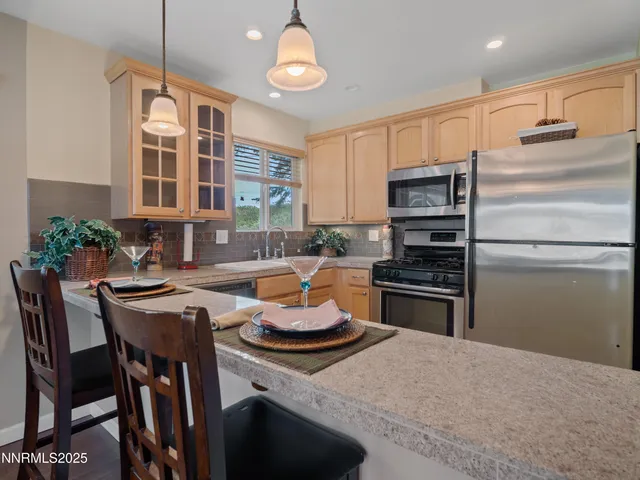 a kitchen with a dining table chairs stainless steel appliances and cabinets