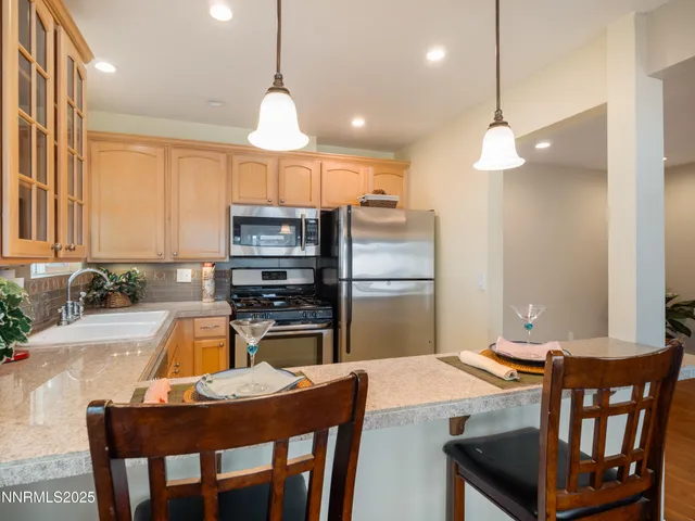 a kitchen with stainless steel appliances granite countertop a refrigerator sink stove microwave and cabinets