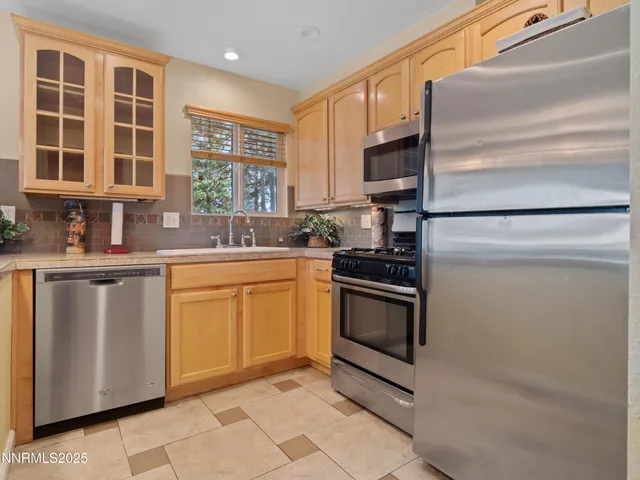 a kitchen with stainless steel appliances granite countertop a stove a refrigerator and a sink
