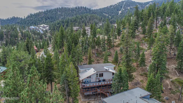 an aerial view of a house with a mountain in the background