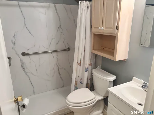 a white toilet sitting next to a bathroom sink