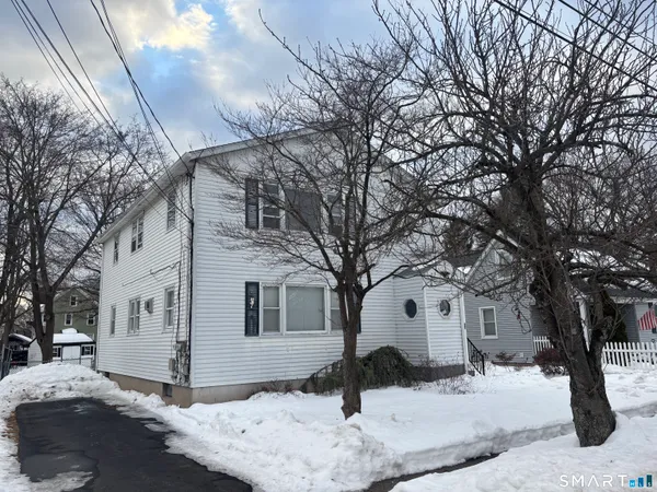 a view of a white house with a snow on the road