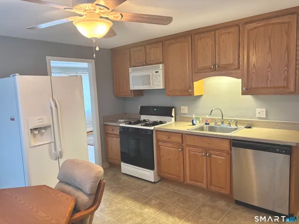 a kitchen with stainless steel appliances granite countertop a sink refrigerator and cabinets
