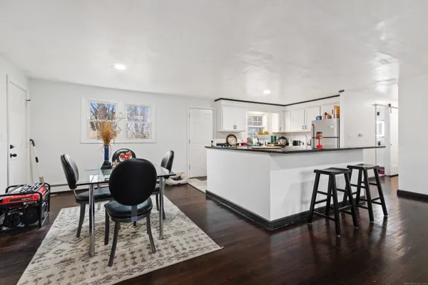 a living room with kitchen and a wooden floor