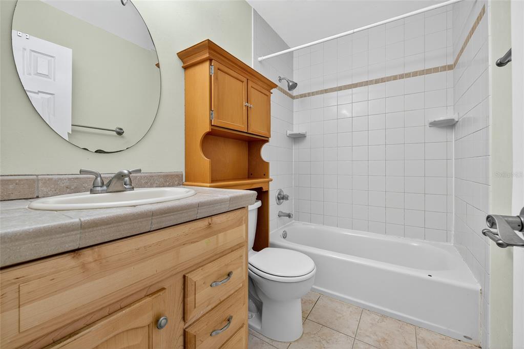 980 Canal View Boulevard, Unit J4 Port Orange, FL 32129 - Photo 14 of 25 a bathroom with a granite countertop sink a toilet and shower