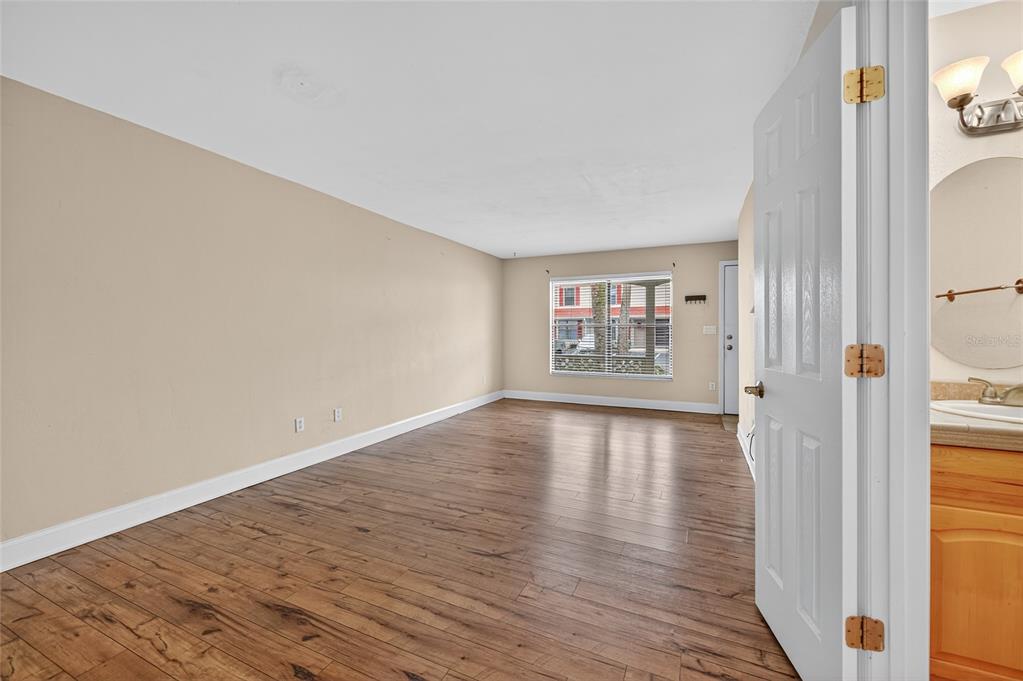 980 Canal View Boulevard, Unit J4 Port Orange, FL 32129 - Photo 6 of 25 a view of an empty room with wooden floor and a window