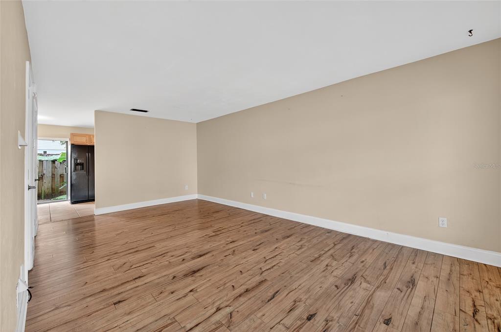 980 Canal View Boulevard, Unit J4 Port Orange, FL 32129 - Photo 8 of 25 a view of an empty room with wooden floor