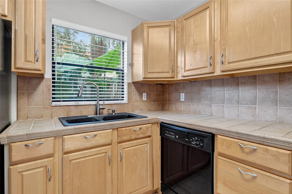 980 Canal View Boulevard, Unit J4 Port Orange, FL 32129 - Photo 10 of 25 a kitchen with granite countertop stainless steel appliances white cabinets sink and window