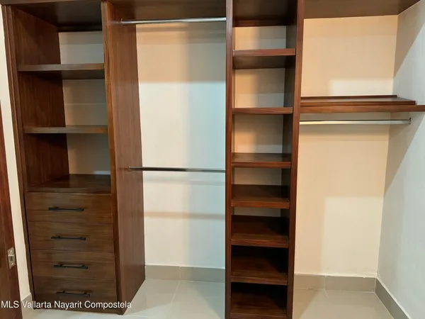a view of walk in closet with empty racks