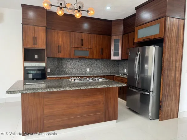 a kitchen with stainless steel appliances granite countertop a refrigerator and a sink