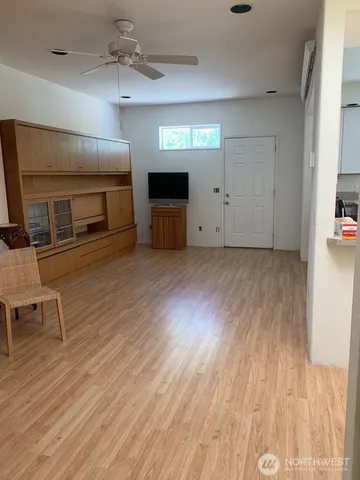 an empty room with wooden floor fireplace and windows