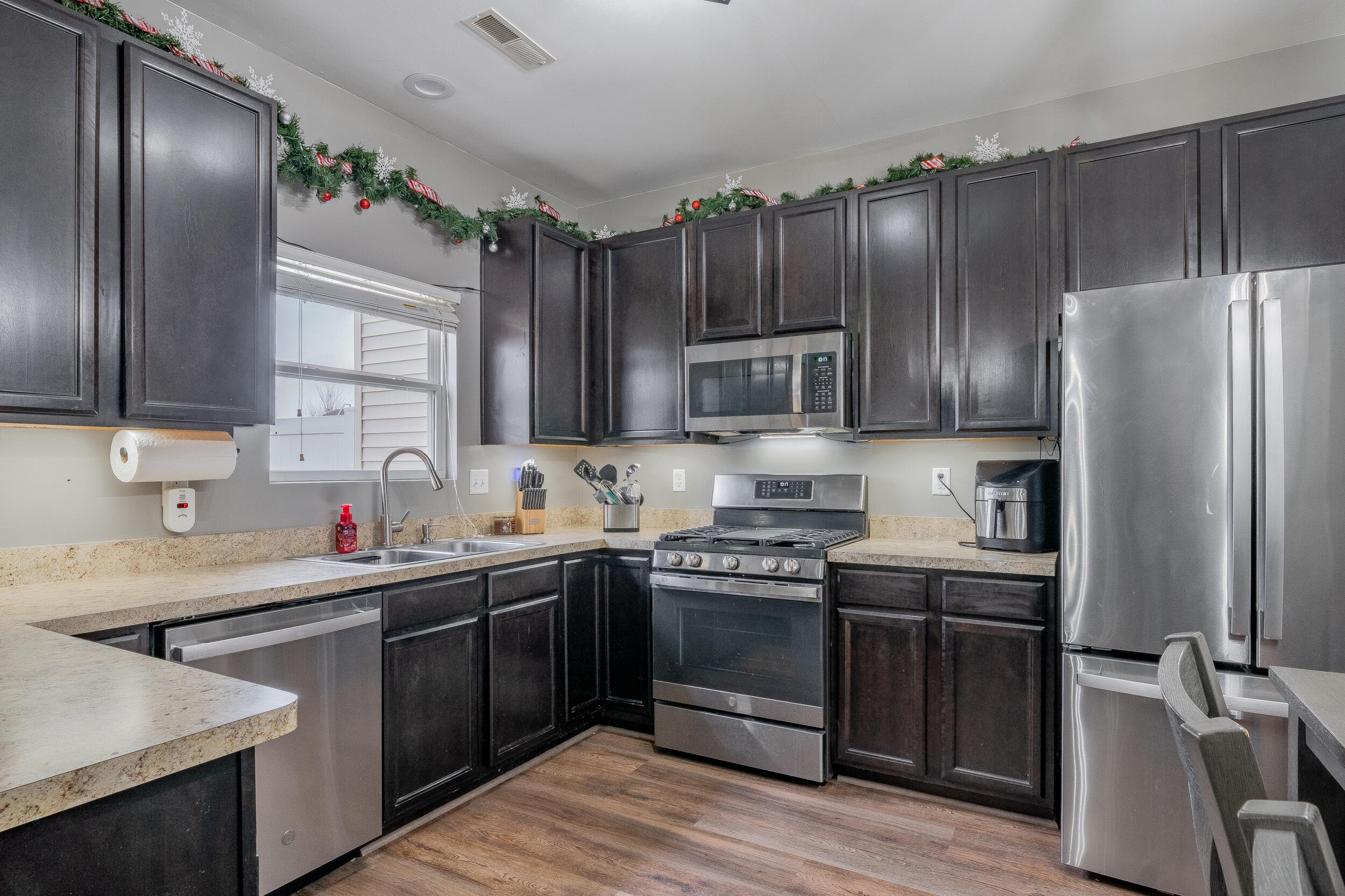 11165 Orange Street Crown Point, IN 46307 - Photo 10 of 33 a kitchen with stainless steel appliances a sink cabinets and wooden floor