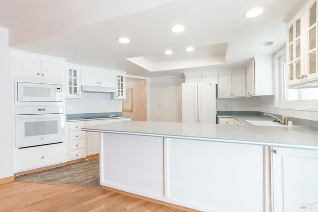 a kitchen with stainless steel appliances granite countertop a sink and a refrigerator