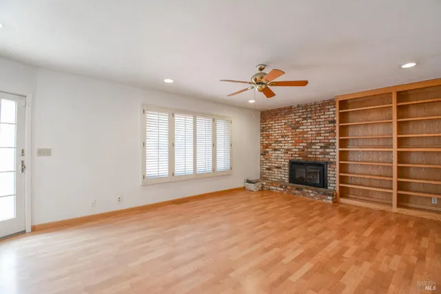 a view of an empty room with a fireplace and a window
