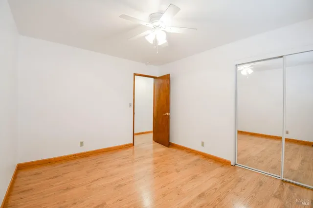 an empty room with a fan and a chandelier fan