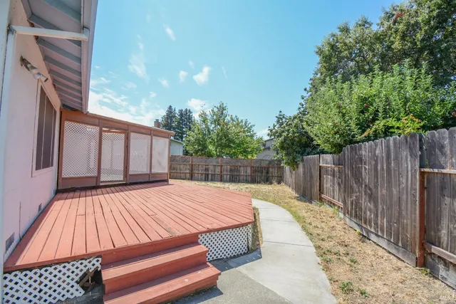 a view of backyard with wooden floor and fence