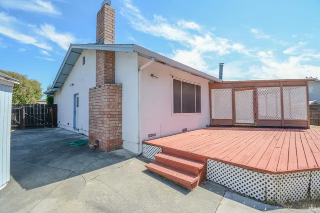 a backyard of a house with barbeque oven table and chairs