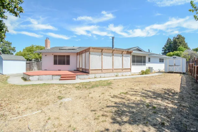 a view of a house with backyard and sitting area