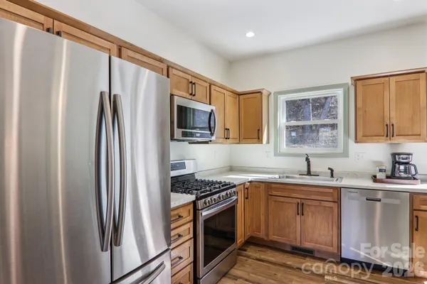 a kitchen with stainless steel appliances a refrigerator sink and microwave