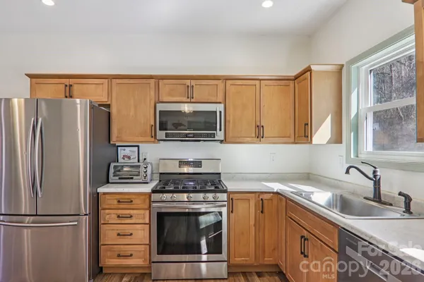 a kitchen with stainless steel appliances a stove sink and refrigerator