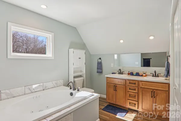 a bathroom with a double vanity sink mirror and bathtub