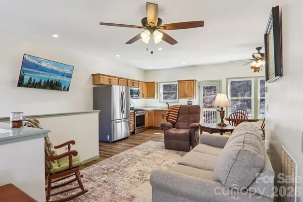 a living room with furniture a flat screen tv and kitchen view