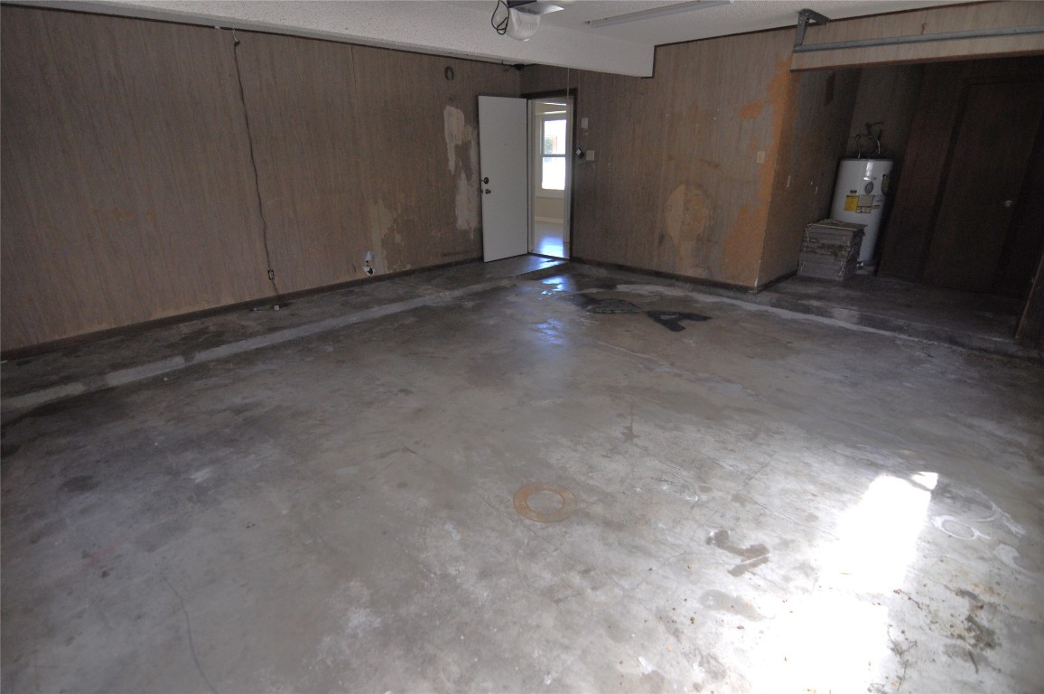 13203 Stillforest Street Austin, TX 78729 - Photo 11 of 24 Garage with wood walls and water heater