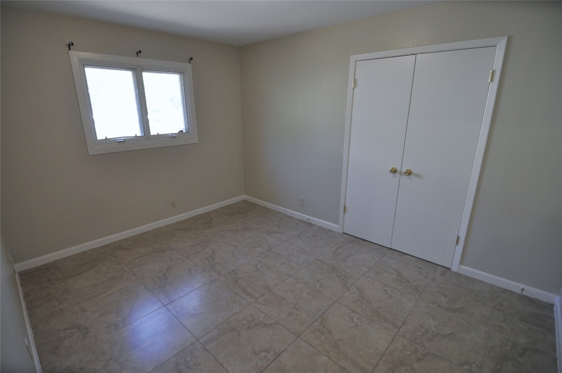 13203 Stillforest Street Austin, TX 78729 - Photo 14 of 24 Unfurnished bedroom featuring baseboards and a closet