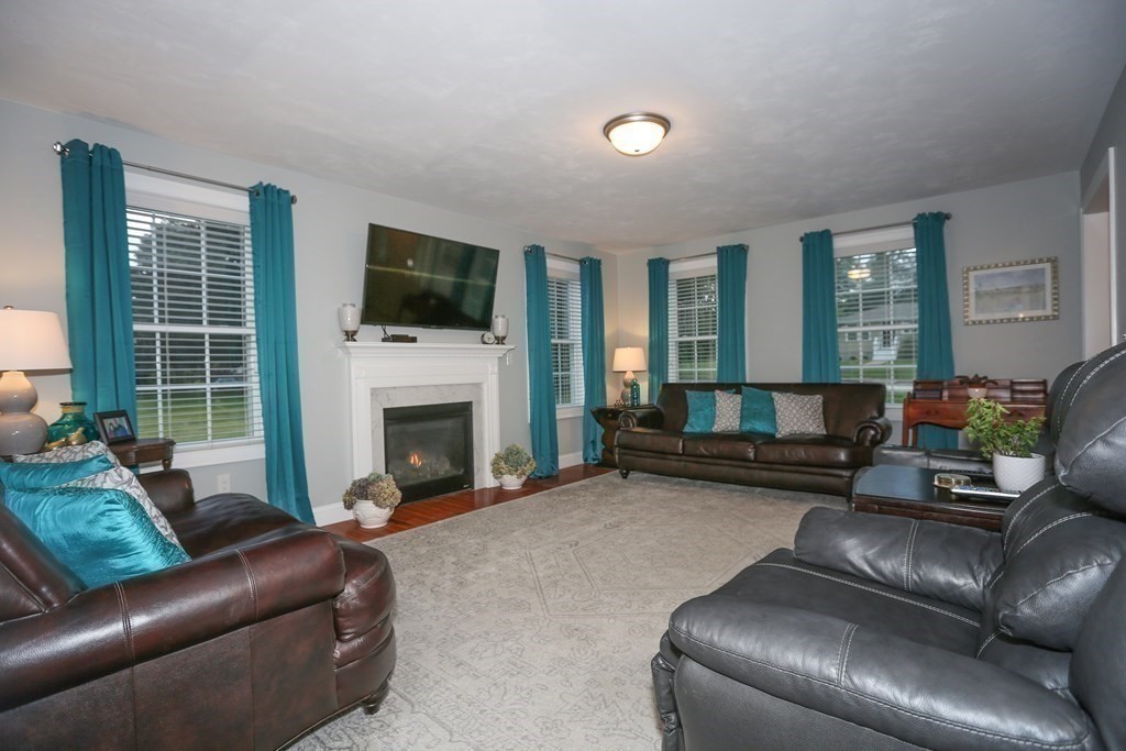 3 Jade Hill Road Auburn, MA 01501 - Photo 13 of 27 a living room with furniture a flat screen tv and a fireplace