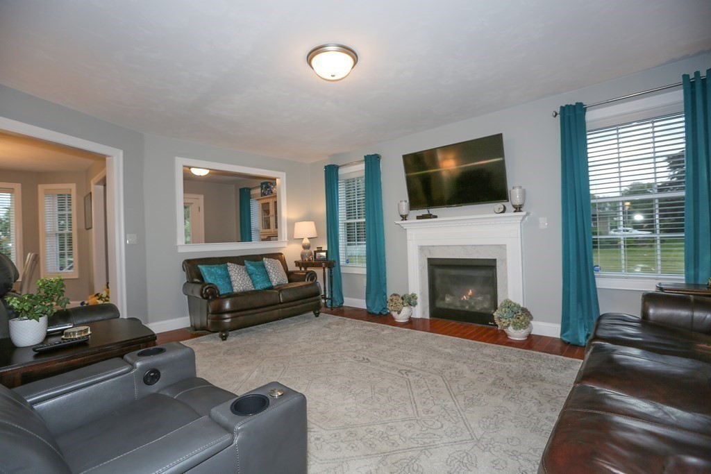 3 Jade Hill Road Auburn, MA 01501 - Photo 15 of 27 a living room with furniture a flat screen tv and a fireplace