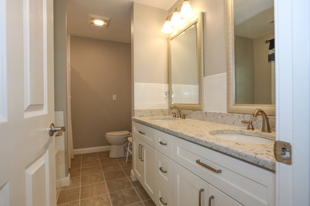 3 Jade Hill Road Auburn, MA 01501 - Photo 20 of 27 a bathroom with a granite countertop sink a toilet and a mirror