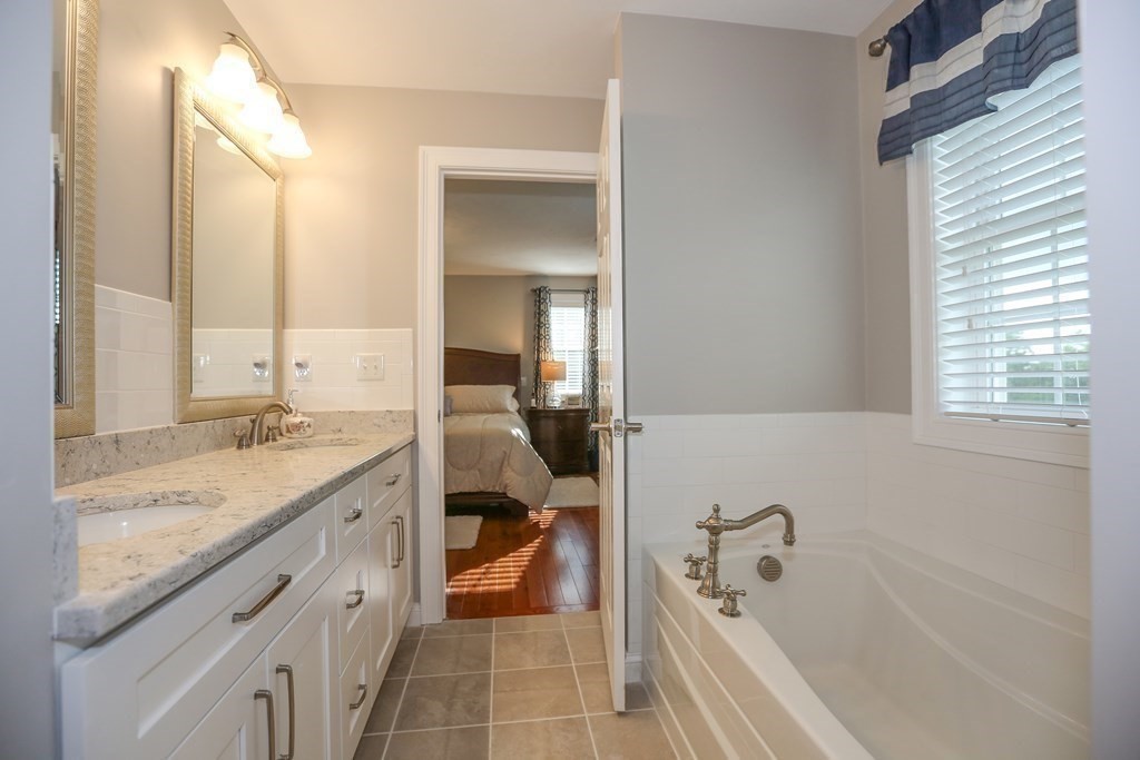 3 Jade Hill Road Auburn, MA 01501 - Photo 21 of 27 a bathroom with a granite countertop tub sink and mirror