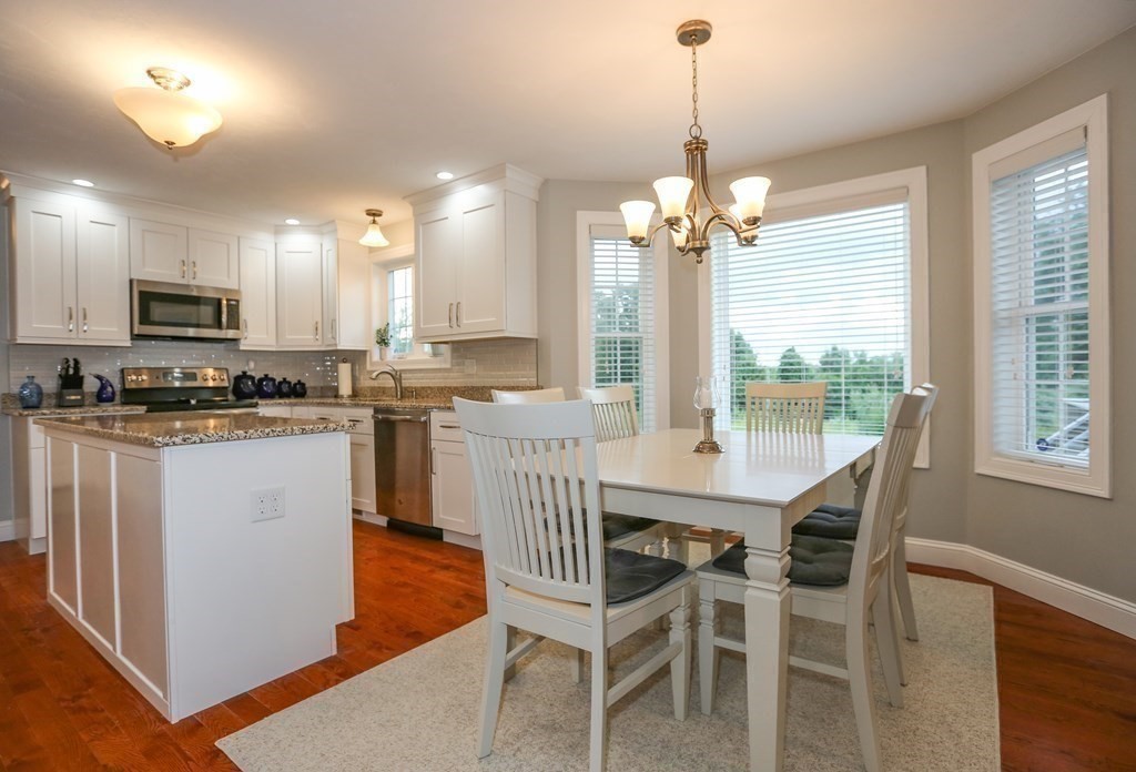3 Jade Hill Road Auburn, MA 01501 - Photo 6 of 27 a kitchen with stainless steel appliances granite countertop a stove a sink a microwave a dining table and chairs