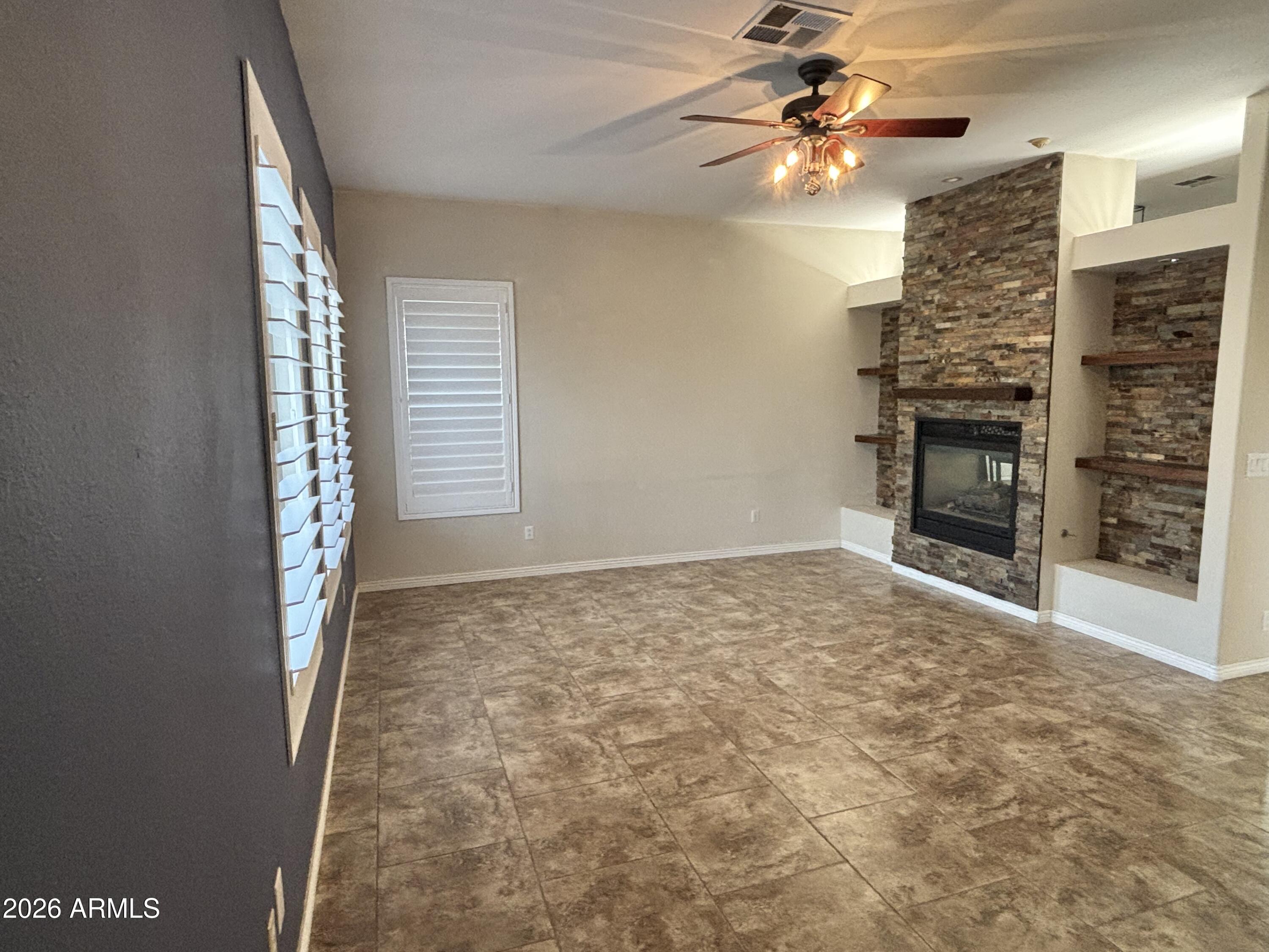 434 East Sheffield Avenue Gilbert, AZ 85296 - Photo 43 of 52 a view of an empty room with a fireplace and fan