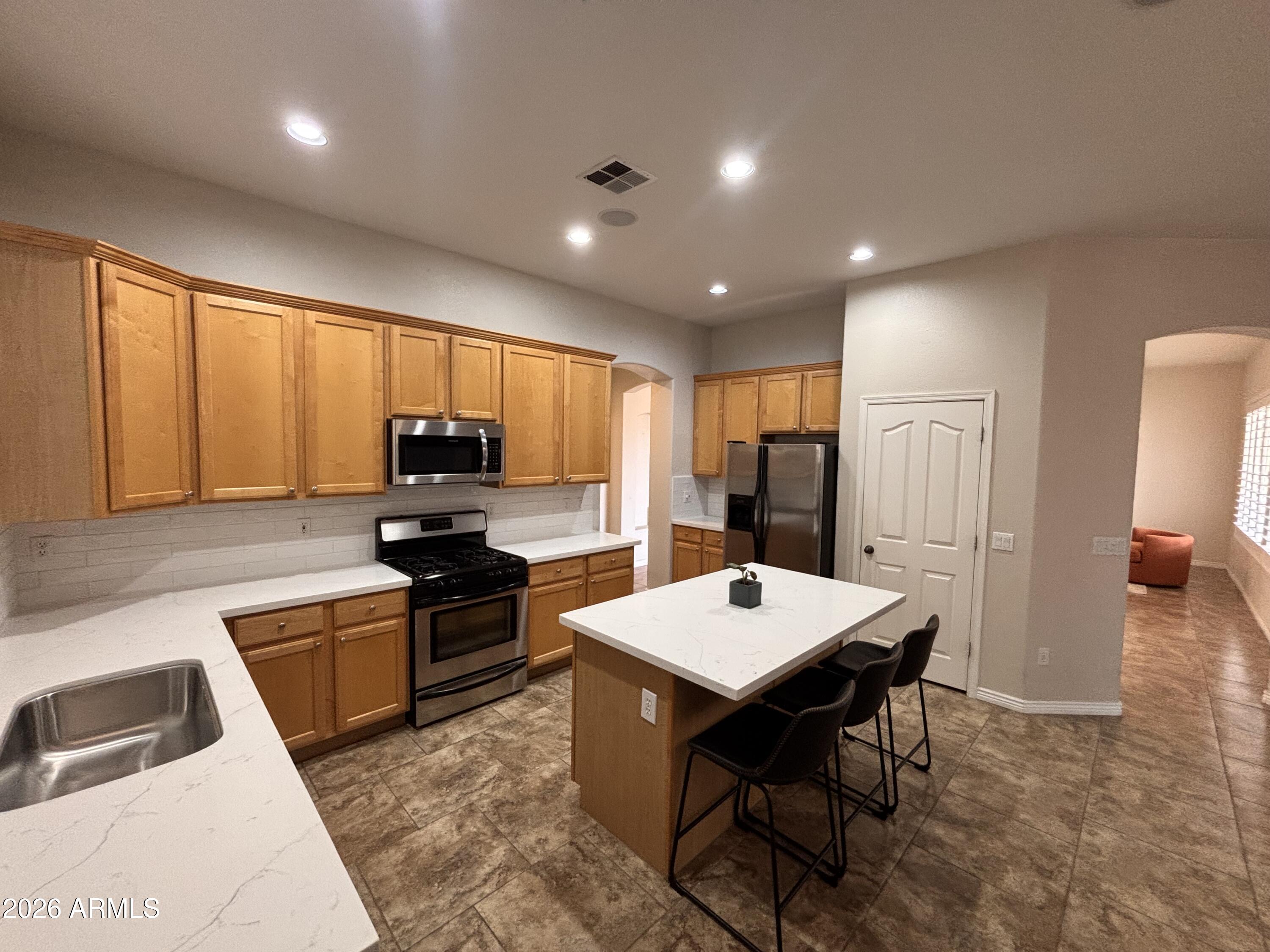434 East Sheffield Avenue Gilbert, AZ 85296 - Photo 51 of 52 a kitchen with a dining table chairs and refrigerator