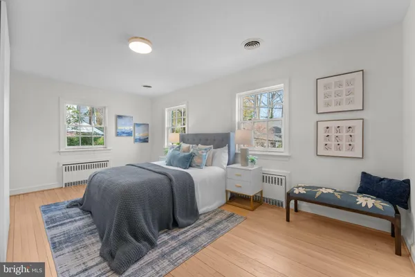 a spacious bedroom with a bed and wooden floor